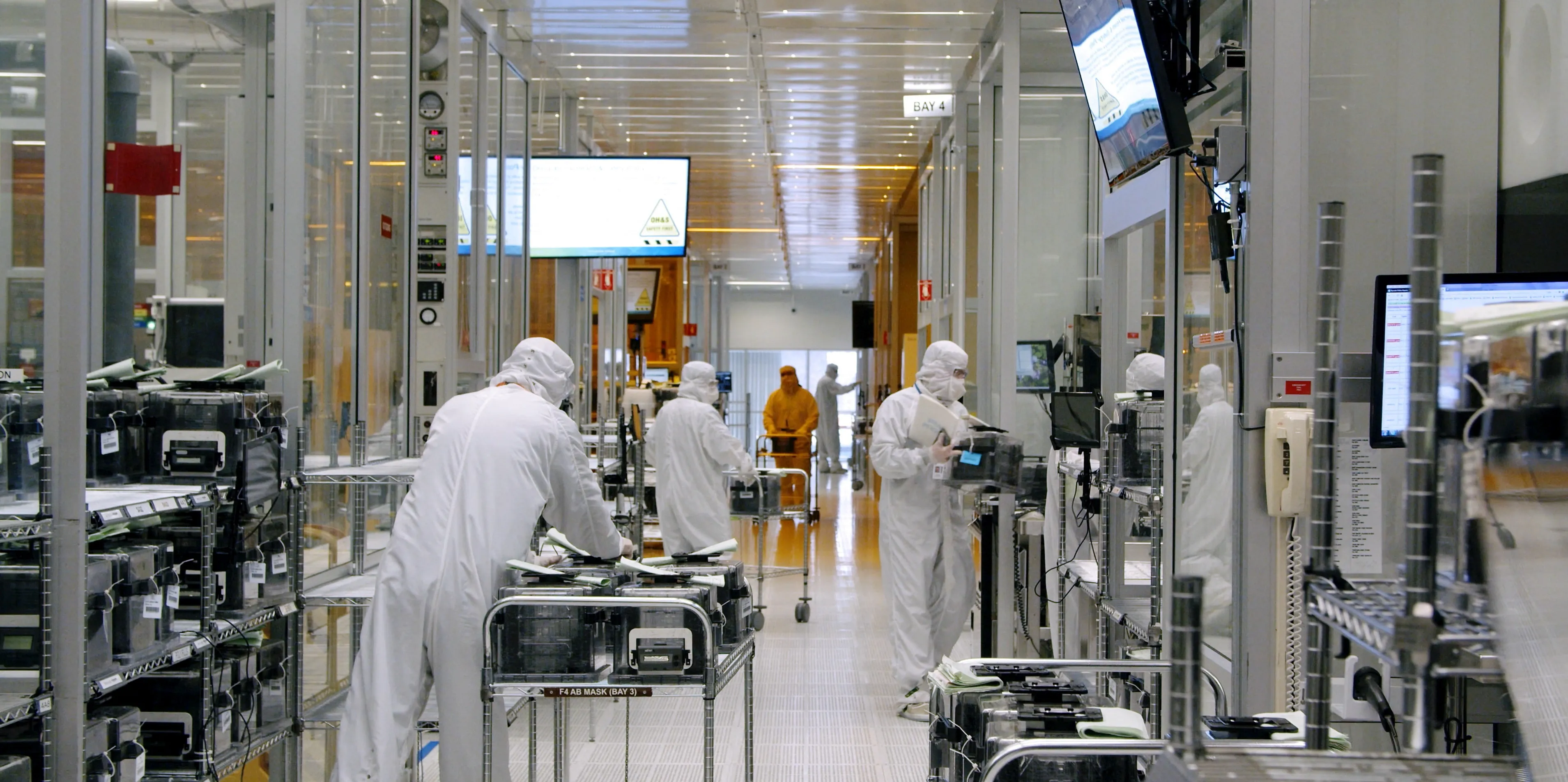 Process technicians at work along a semiconductor fabrication bay