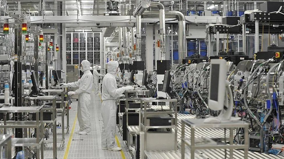 Technicians monitoring process tools along a fabrication line