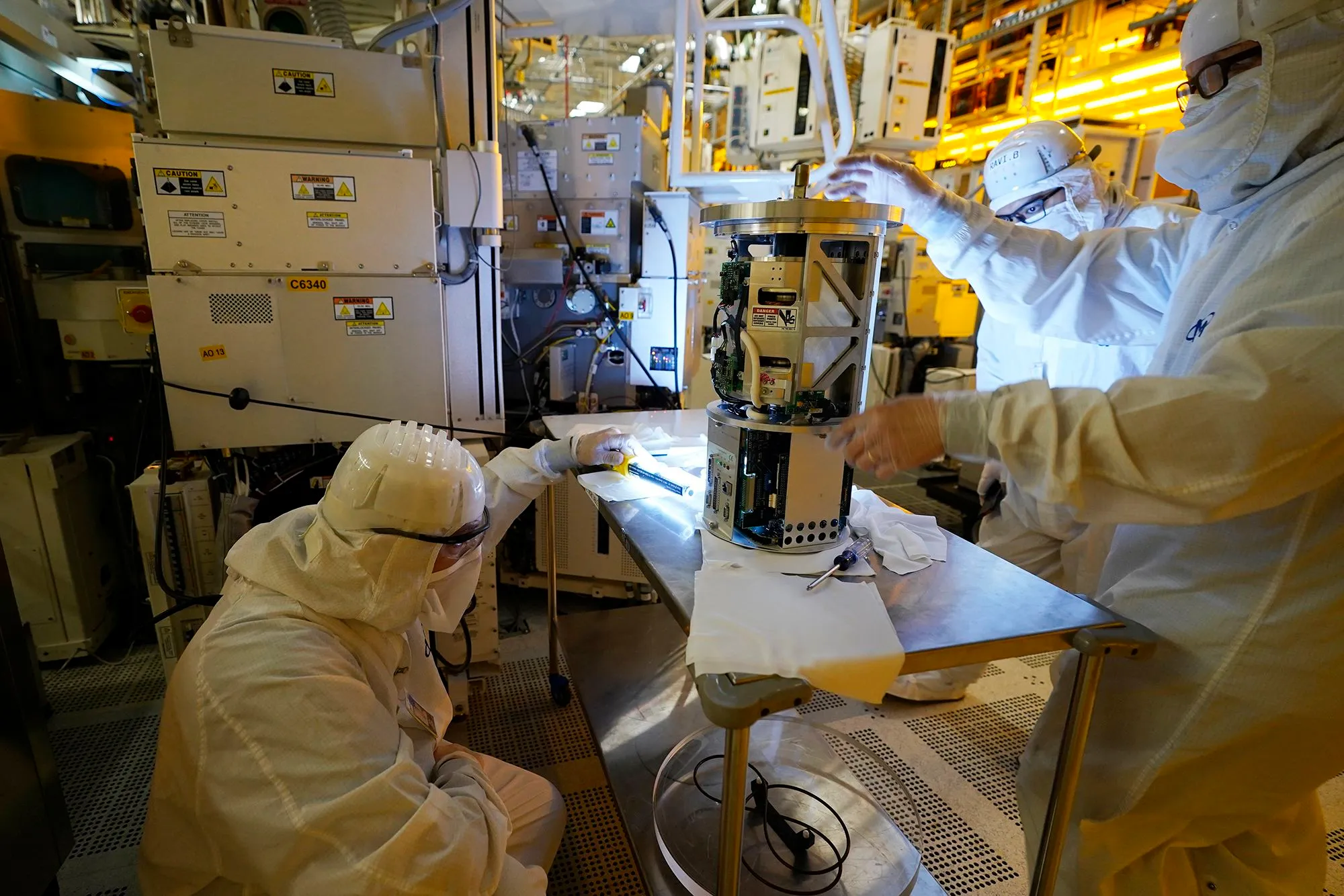 Technicians servicing a process tool subassembly inside a semiconductor fab